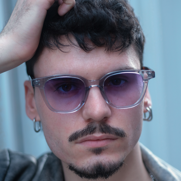 a man wears transparent sunglasses with gradient purple lenses